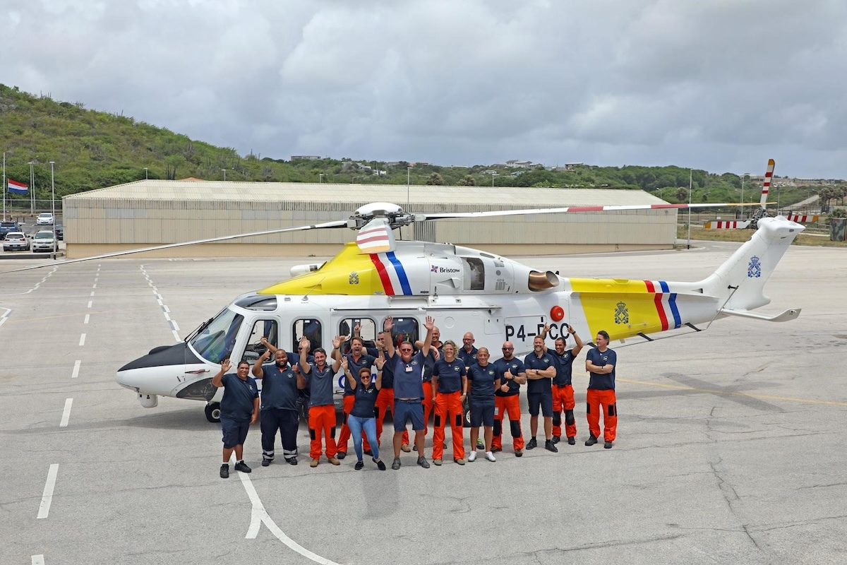 People standing in front of a helicopter